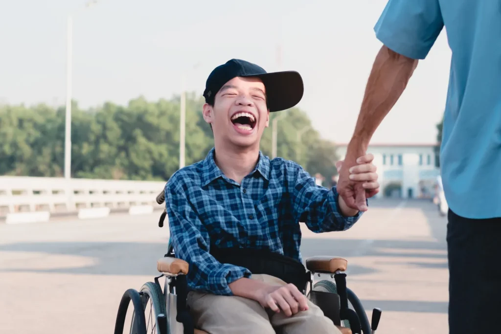 Happy disabled boy in wheelchair smiling