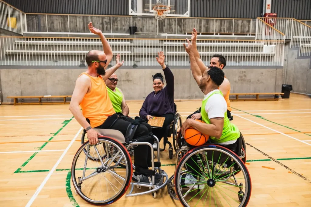 Group of disabled friends in wheelchairs playing basketball